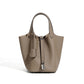 Leather bucket tote bag shown under soft studio lighting