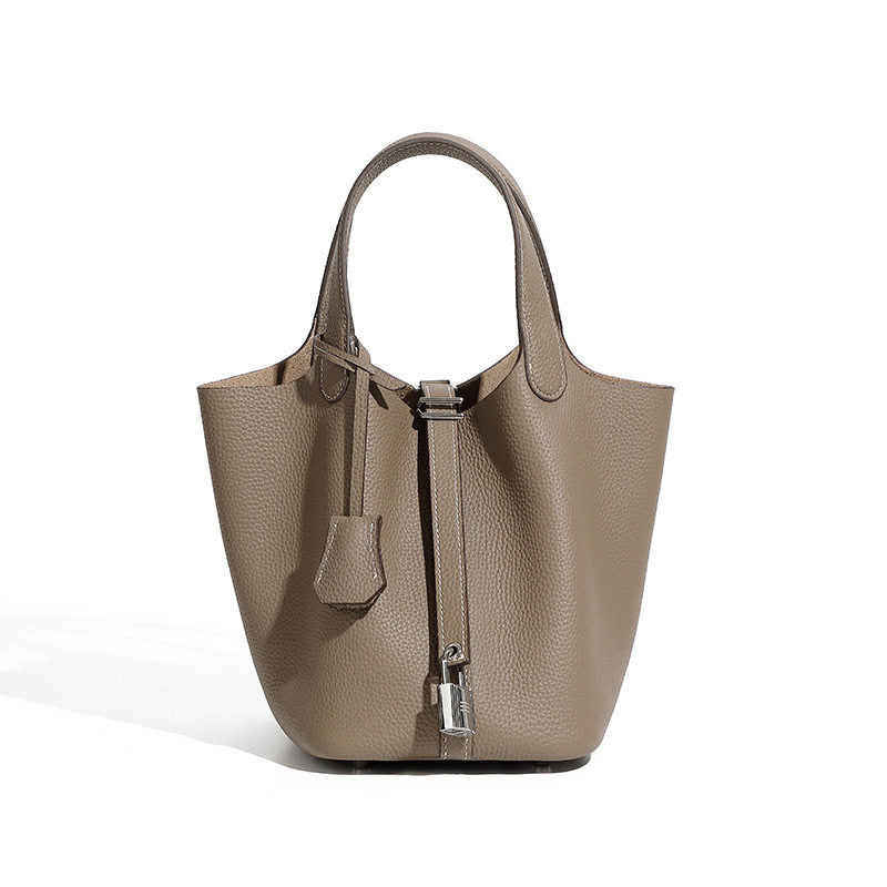 Leather bucket tote bag shown under soft studio lighting