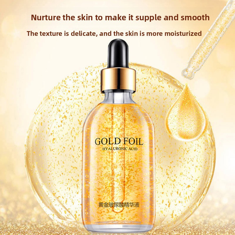 Gold foil essence dropper releasing a drop over a golden splash on a gold background