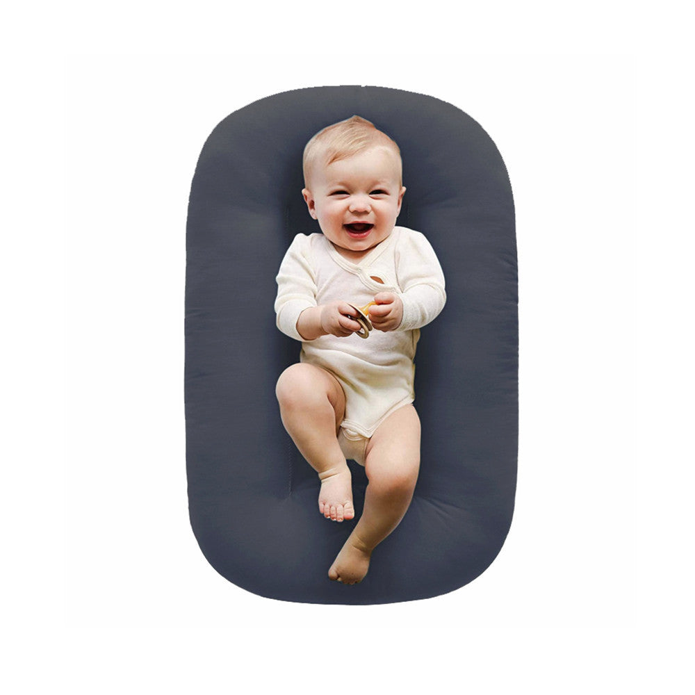 Padded baby lounger nest on an off white background showing the oval shape
