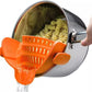 Orange silicone clip-on pot strainer, variant photo, clipped to a pot held by hand with water draining