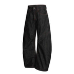 Rolled cuff of the wide leg jean sitting above a low leather sandal
