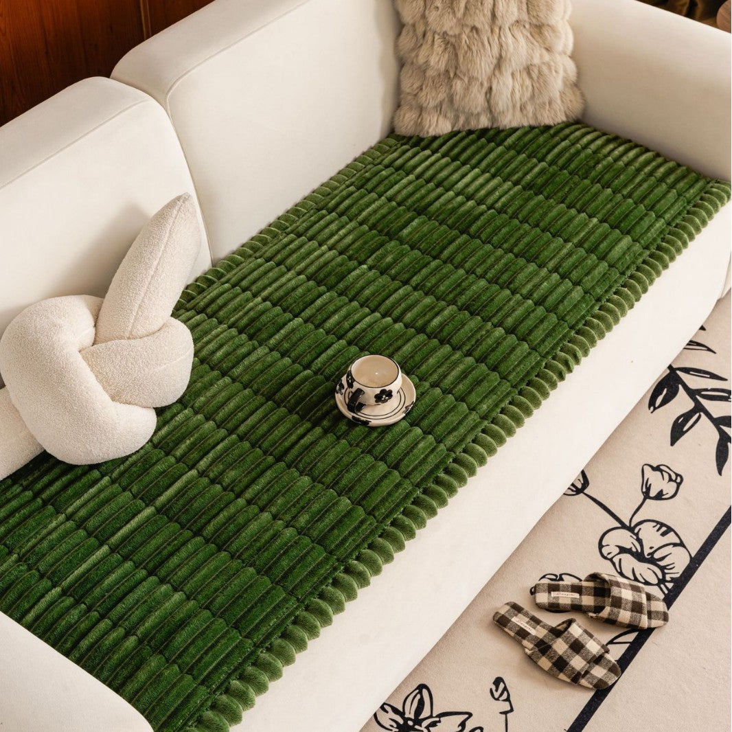 Sweet Serene Dark Green quilted plush sofa cover on a sofa, 90 x 240 cm