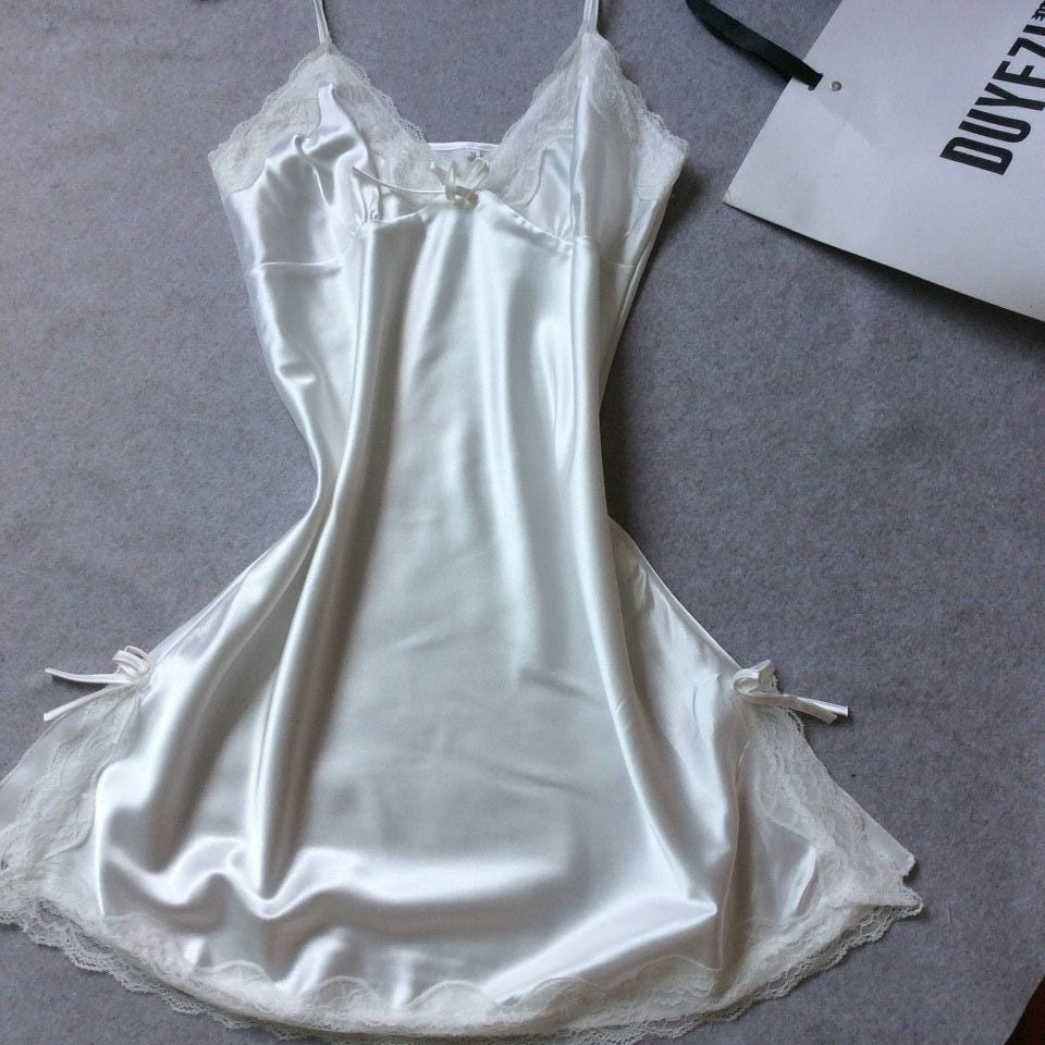 White satin slip nightdress with white lace trim and small bows, flat on a gray cloth, option photo for size XXL