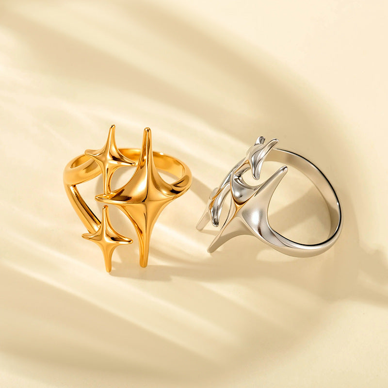 Gold and silver adjustable star rings on cream cloth with open bands visible