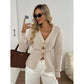 Front view of an apricot knit cardigan showing the deep V neck and three gold tone buttons