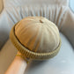 Brimless beanie with a ribbed knit band shown from the side
