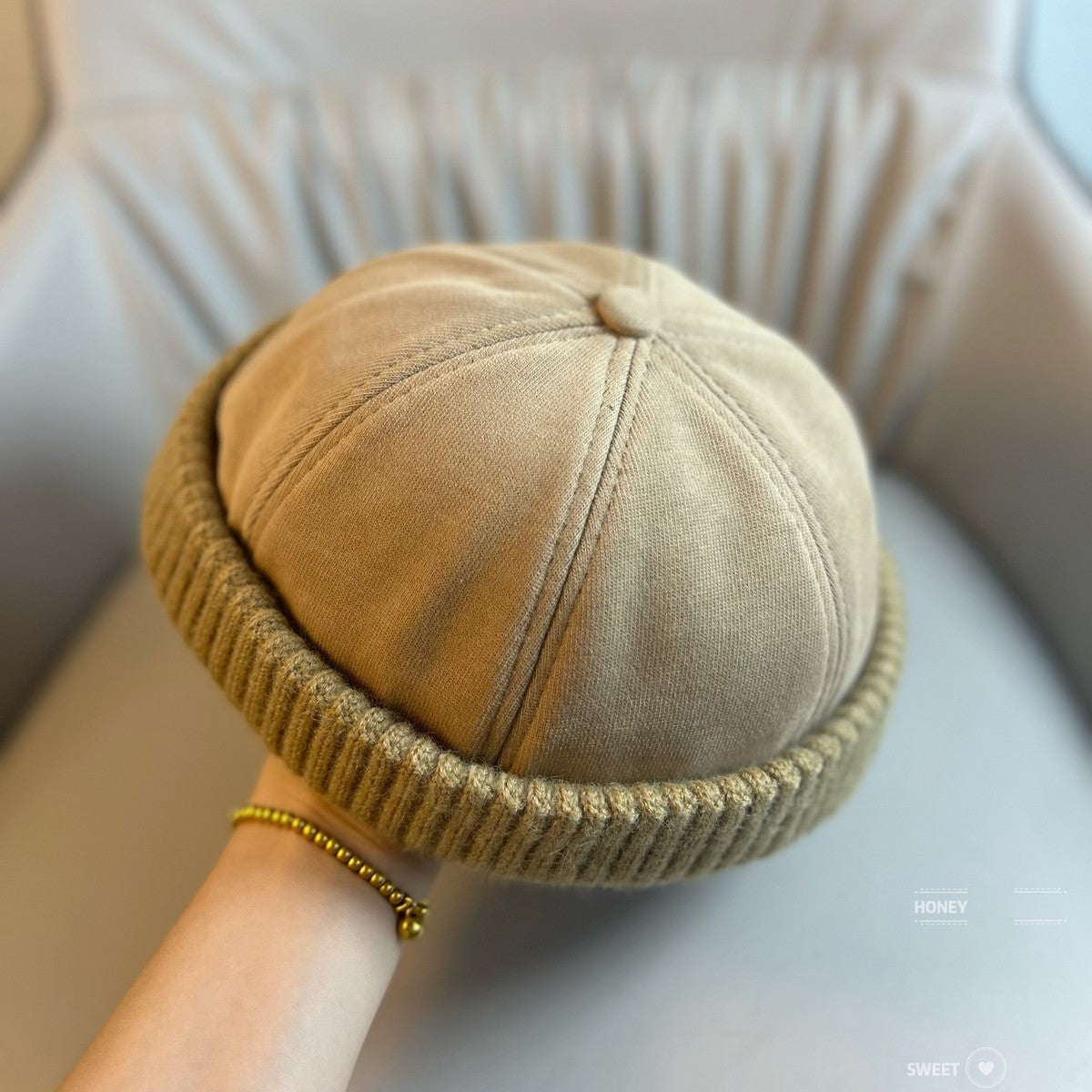 Brimless beanie with a ribbed knit band shown from the side