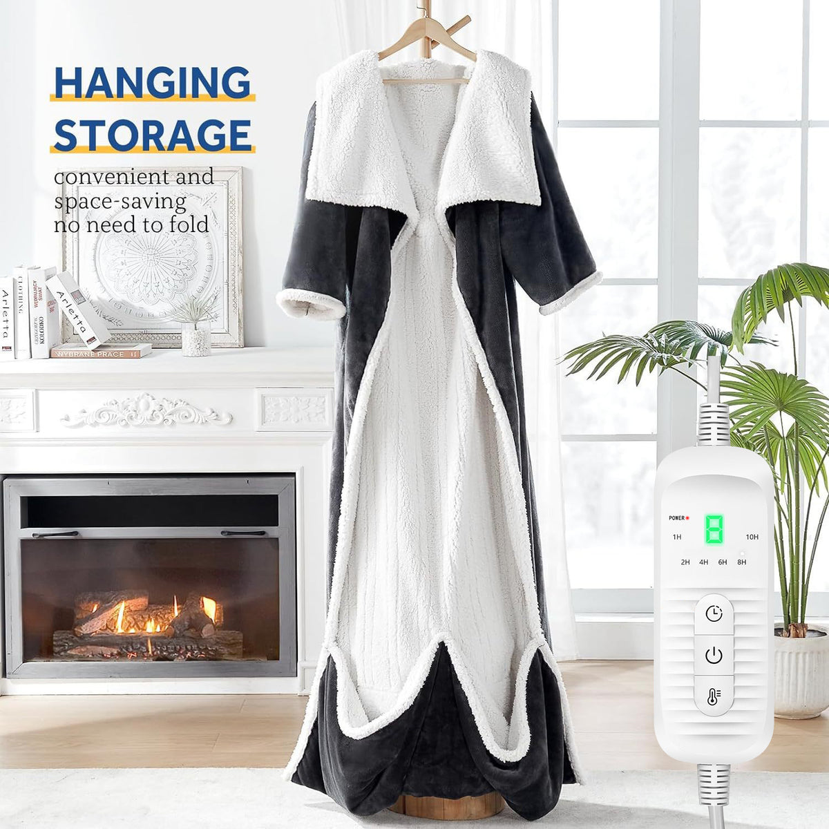 Dark gray wearable electric blanket with foot pockets hanging on a hanger beside a fireplace, CE EU 130x180 cm option
