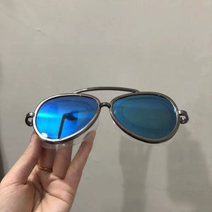 Blue mirror aviator swim goggles with a metallic frame held in a hand
