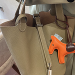 Leather bucket tote bag front view showing the rounded body and top clasp