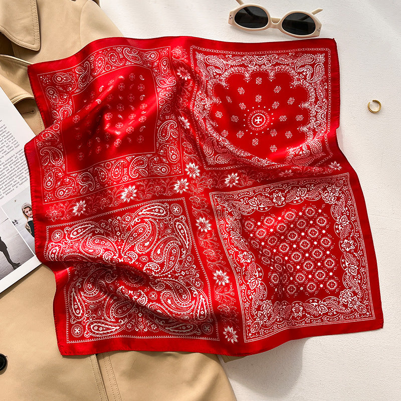 Red bandana paisley printed square scarf with a satin sheen and hemmed edges, shown displayed and knotted