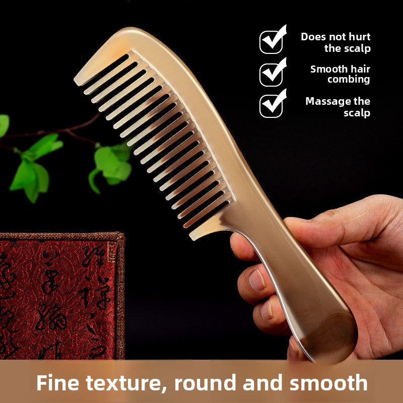 Marbled amber plastic hair comb held in hand to show its compact travel size