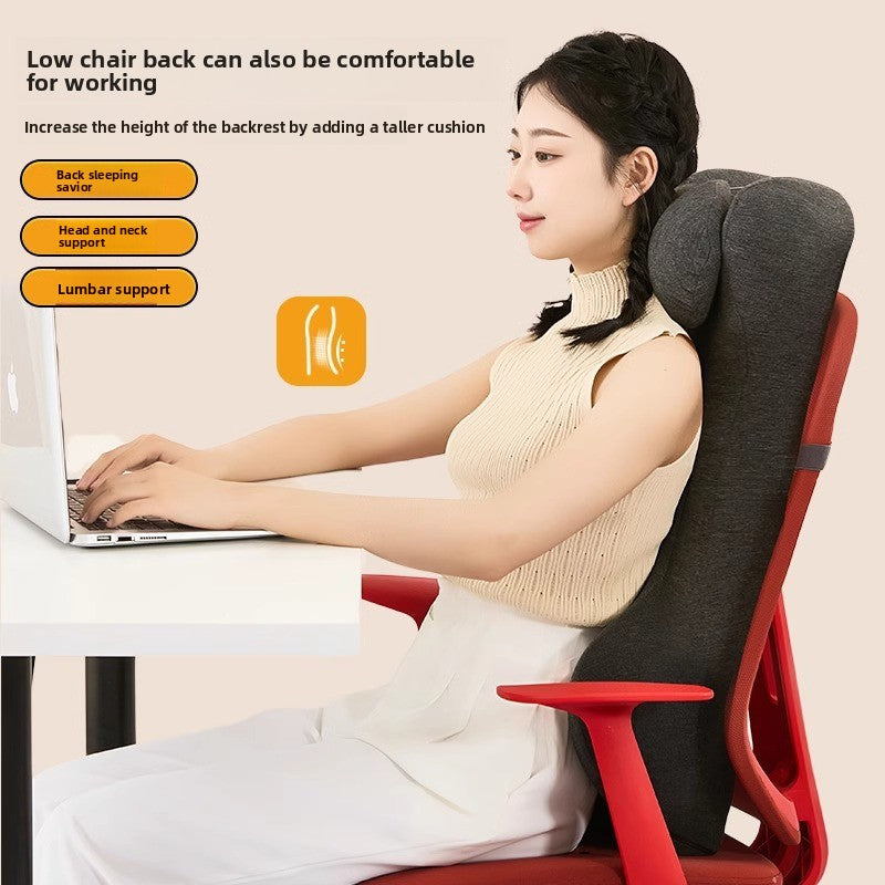 Grey back support cushion with neck rest strapped to an office chair at a desk