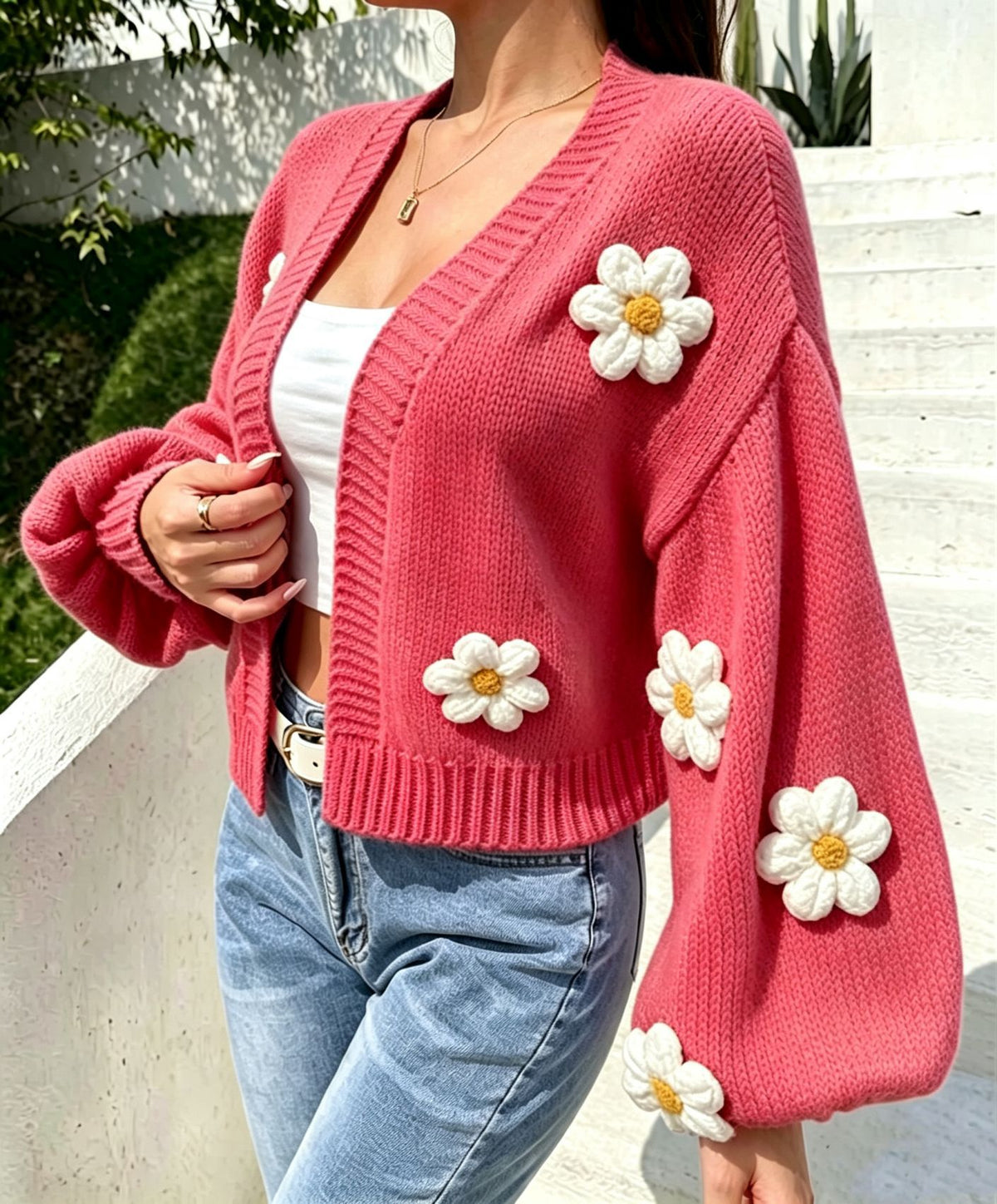 Cropped floral knit cardigan worn open over a plain top on a model