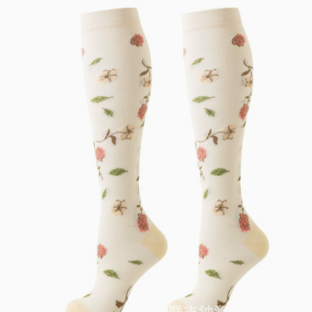 Pair of ivory knee-high compression socks with large pink flowers, green leaves and a yellow heel, size L/XL