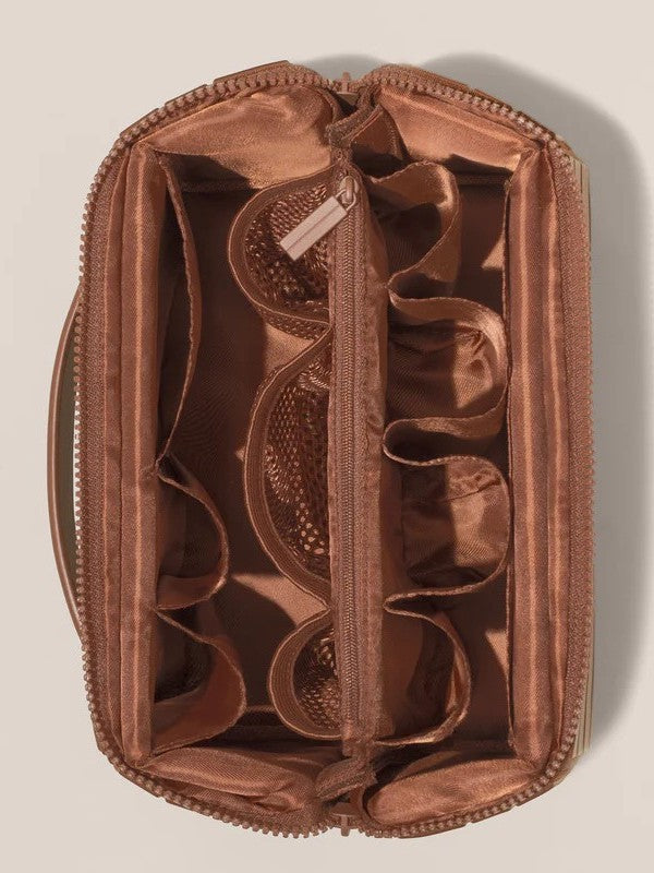 Satin lined interior of the makeup organizer showing padded compartments, mesh pockets and elastic loops