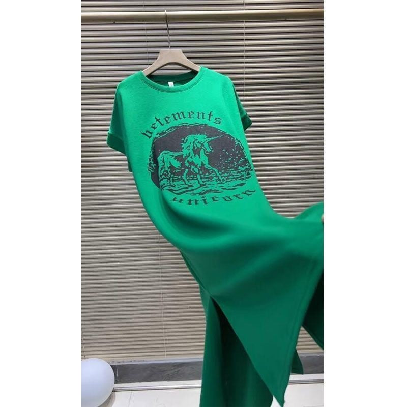 Green loose women's dress draped to the side with unicorn print and gothic lettering
