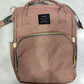 Dusty pink diaper backpack front view on a white surface with two top handles and a front zip pocket