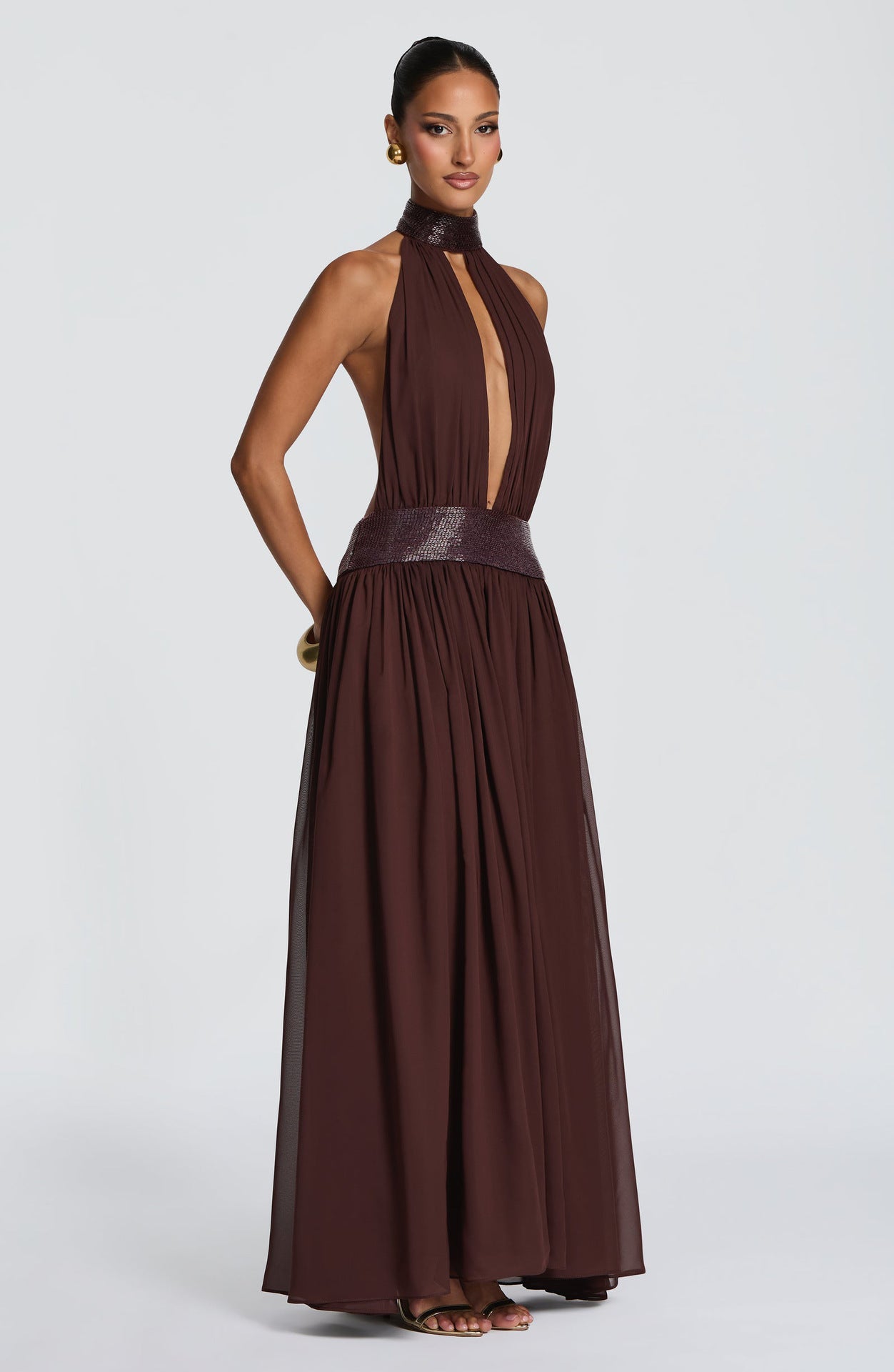 Backless halter chiffon maxi gown with sequin collar, hands resting in the hidden side seam pockets