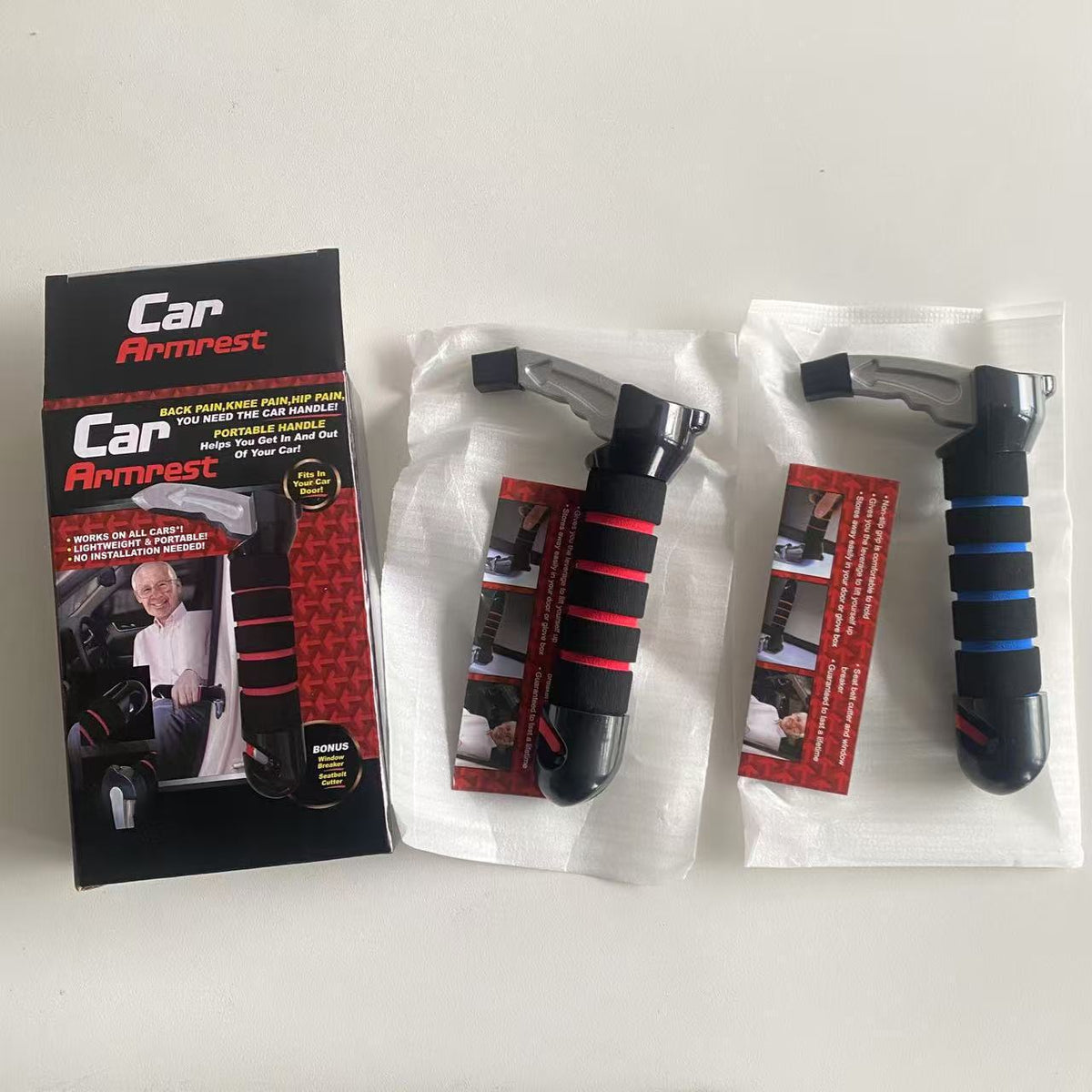 Retail box beside two portable car assist handles, one with a red foam grip and one with a blue foam grip