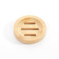 Round bamboo soap dish with a shallow well and three drain slots on a white background