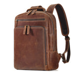 Brown cowhide leather backpack with contrast stitching, front zip pockets and curved shoulder straps