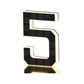 Black and gold solar LED house number sign, one character with a backlit warm outline, angled view