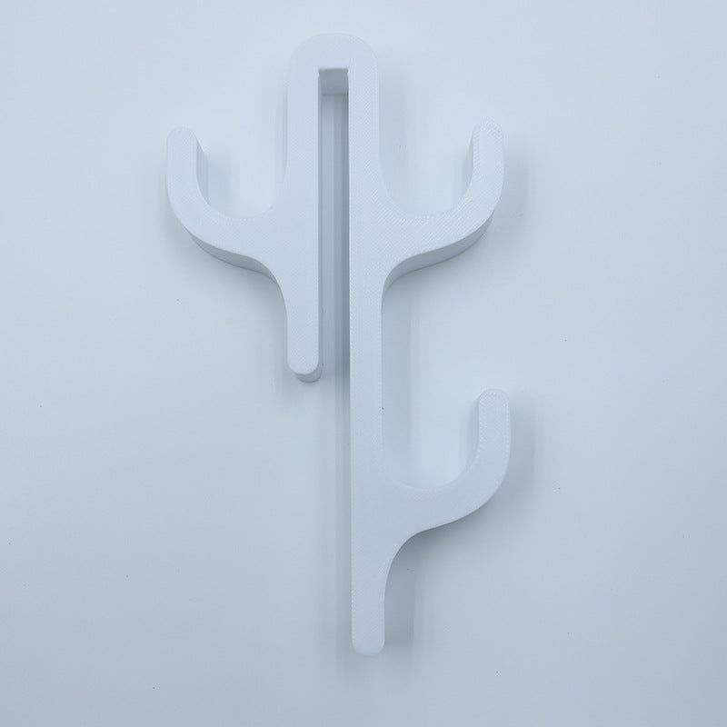 White resin three hook with three arms, seen from the front on a light background