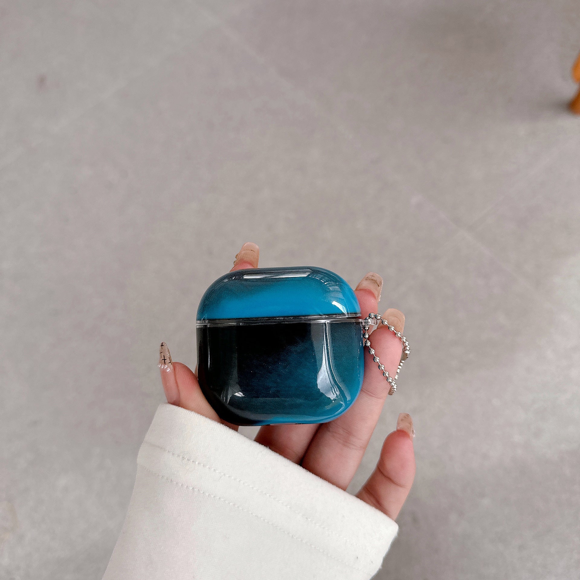 Marble AirPods cover case shown with the open charging port at the base