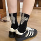 Both colourways of the 3D cartoon cat crew socks laid in a woven basket