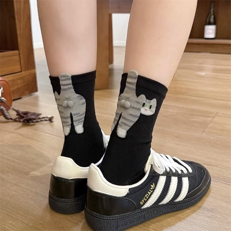 Both colourways of the 3D cartoon cat crew socks laid in a woven basket
