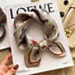 Cream equestrian animals printed square scarf with a satin sheen and hemmed edges, shown displayed