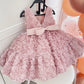 Side profile of the pink rosette party dress showing the full skirt and back bow