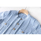 Close up of light blue dress fabric and ruffled sleeve detail