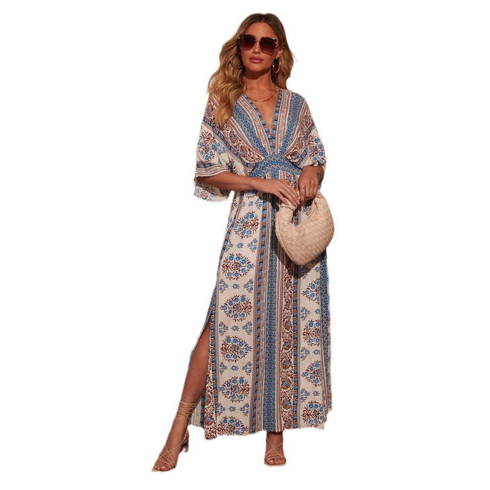 Ivory folk floral print maxi dress banded in blue and rust, worn with sunglasses and a woven bag
