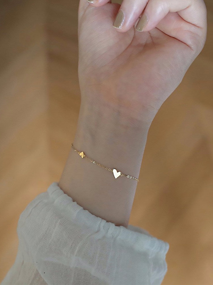 Side profile of the heart bracelet showing the rounded heart and slim chain links
