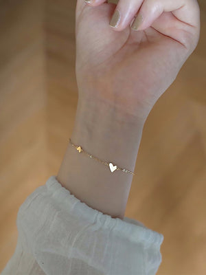 Side profile of the heart bracelet showing the rounded heart and slim chain links
