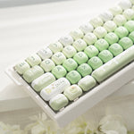 Compact 68 key mechanical keyboard with matcha green MOA keycaps on a white case
