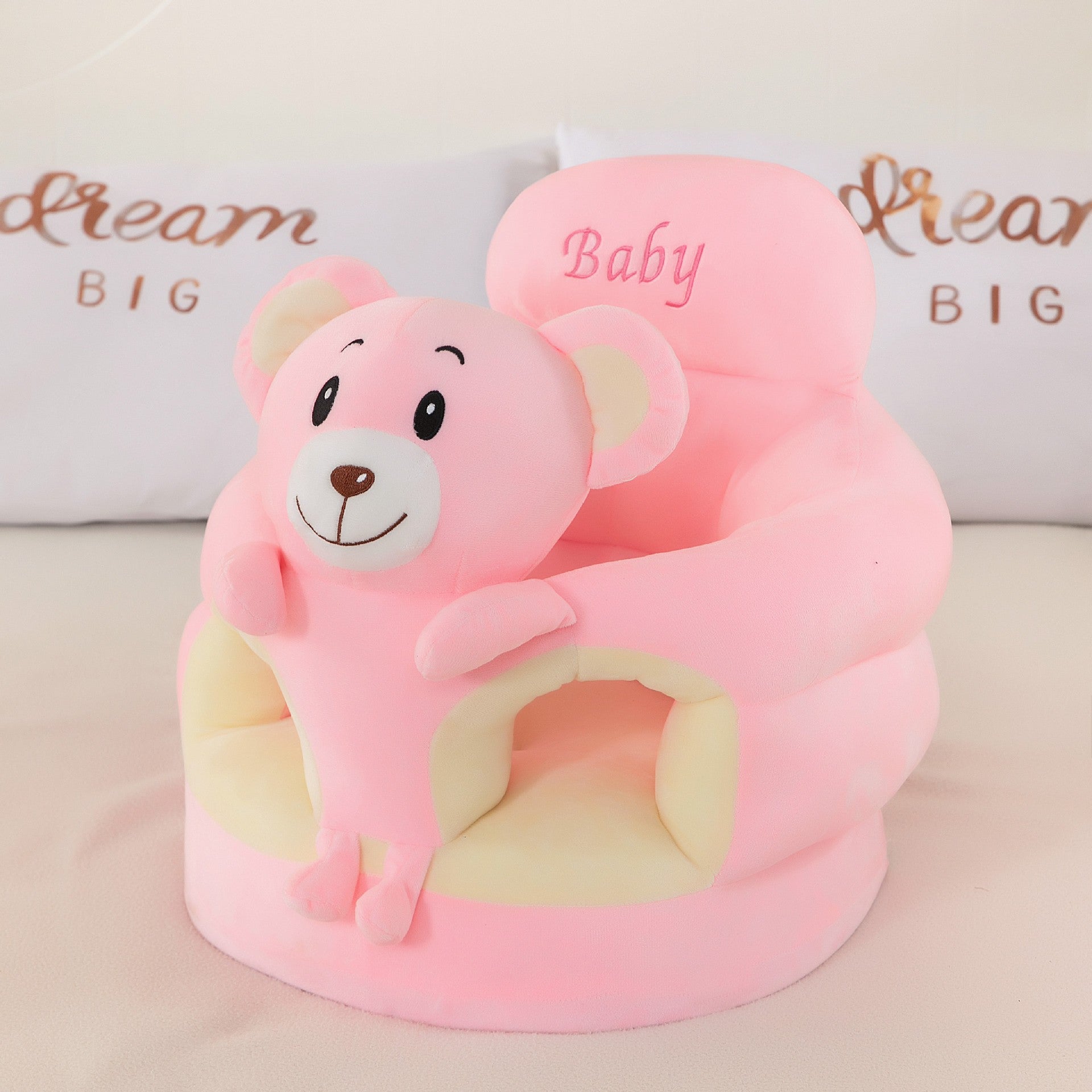Plush baby floor seat with an animal at the front and a soft padded ring for a baby to sit in