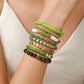 Green colorway stretch beaded bracelet set styled on the wrist with stone and clay strands