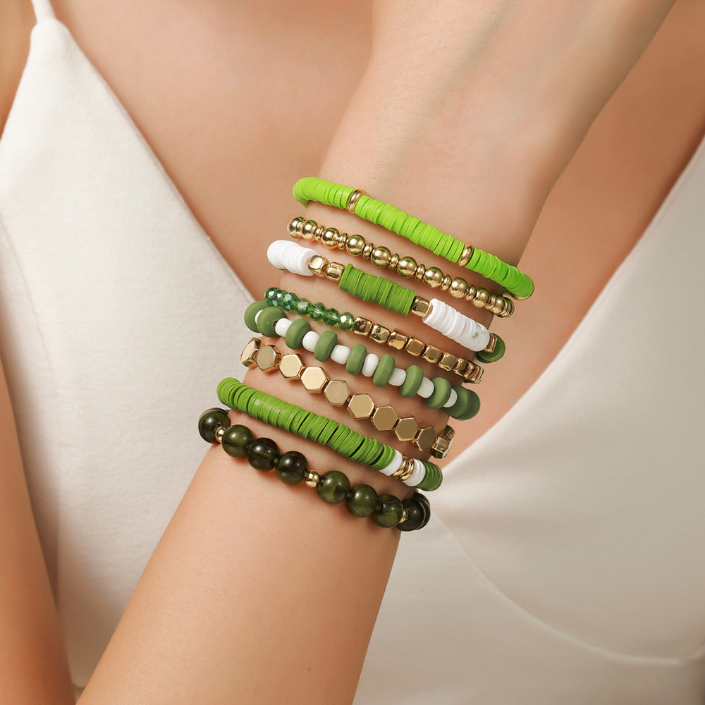 Green colorway stretch beaded bracelet set styled on the wrist with stone and clay strands