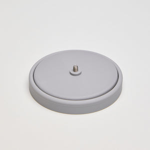 Rotating plastic yarn spool holder with a weighted base and rounded pillar holding a ball of yarn