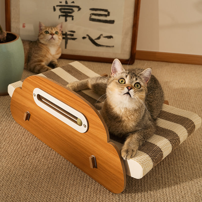 Cat resting on the striped corrugated lounger with a second cat behind it and the catnip slot in the headboard