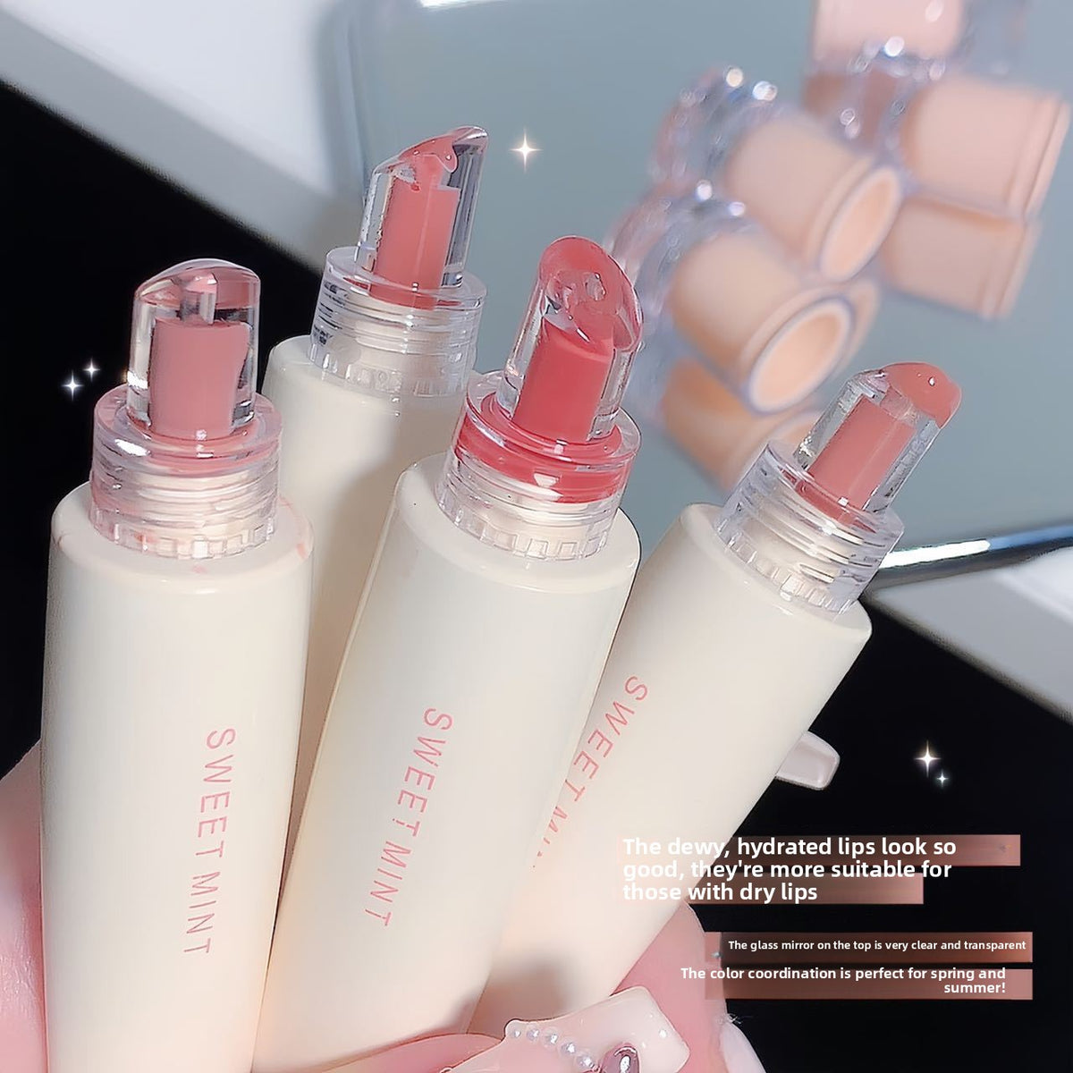 Four cream lip glaze tubes held up showing rounded glossy applicator tips in rosy nude shades