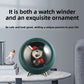 Emerald green watch winder used as a desk ornament on a marble table with books and a figurine