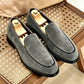 Gray vegan suede slip-on loafers with black piping and a round toe, shoe trees inside, on a bench, size 39 option