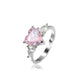 Heart cut pink stone ring with pear shaped clear accents on an open adjustable shank, white background