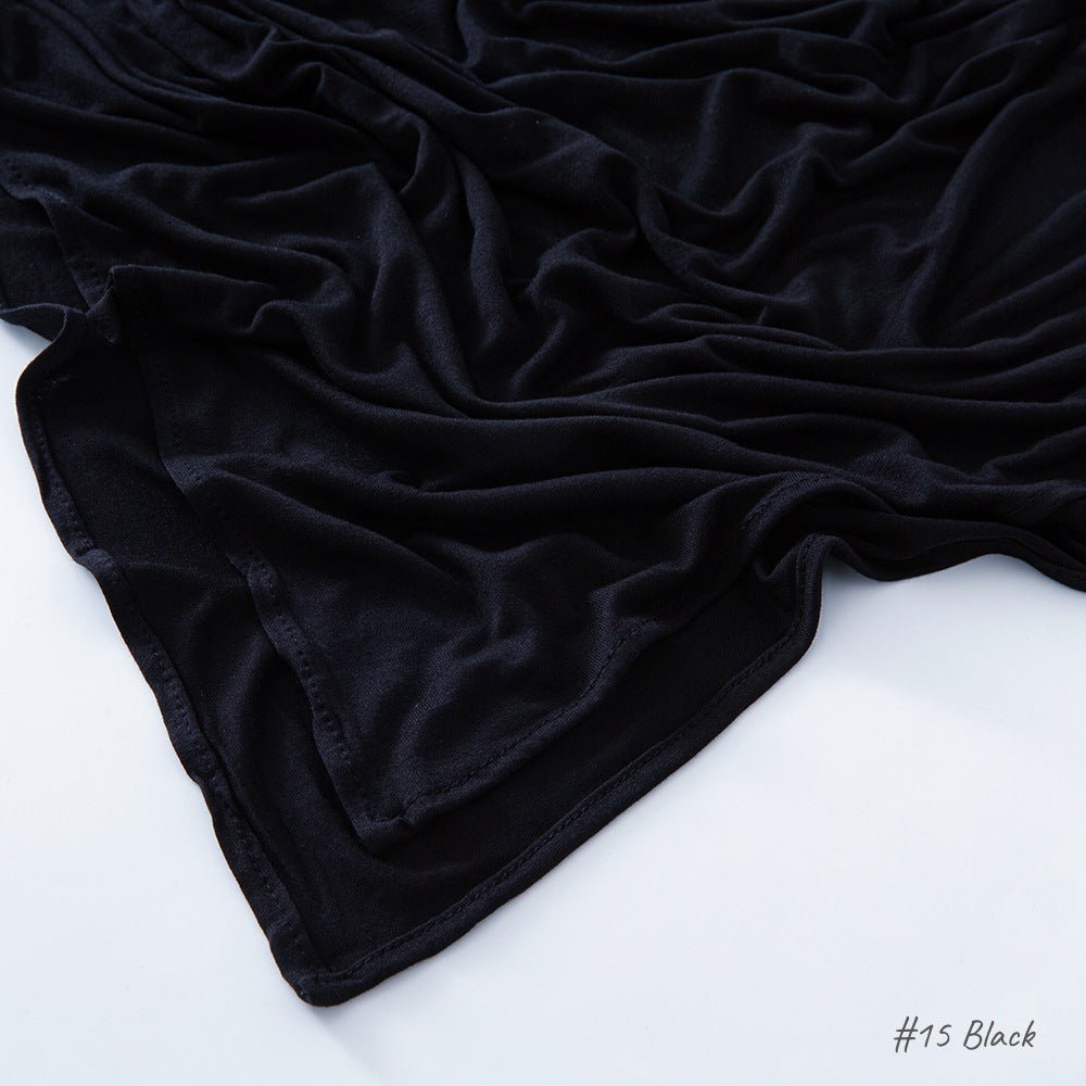 Corner of the modal cotton headscarf wrap showing the neat rolled hem and flat solid color