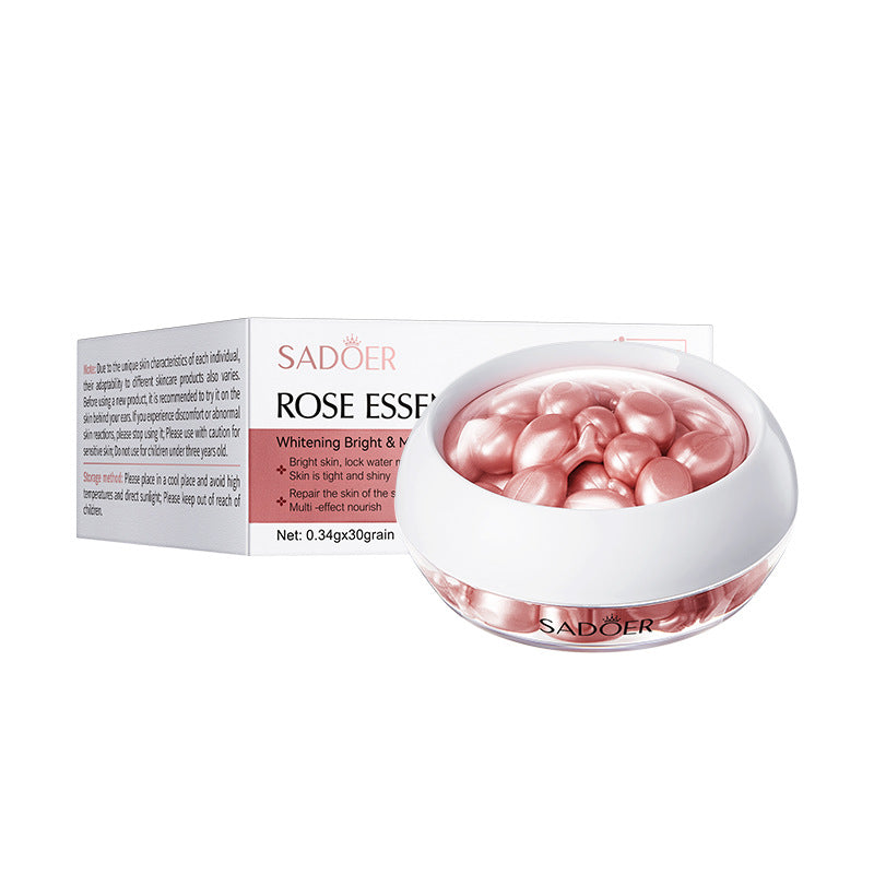 Pink rose essence capsules in a jar beside the rose essence box